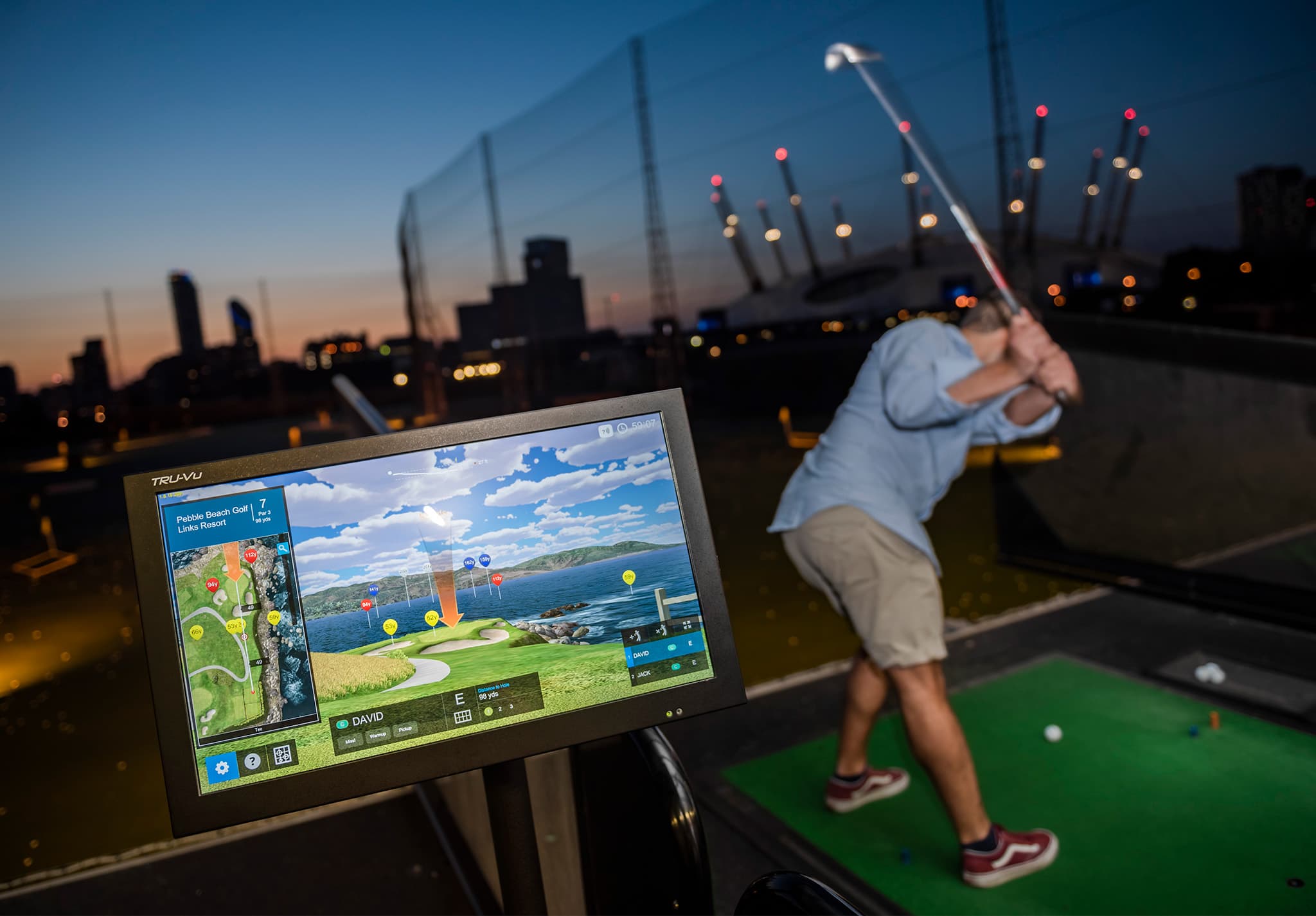 Man on driving range at night